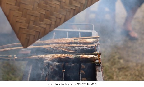 A Man Who Is Grilling Fish Traditionally Uses A Grill To Sell And See The Smoke. 