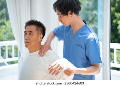 A man who massages and a Japanese senior man who receives treatment - Powered by Shutterstock