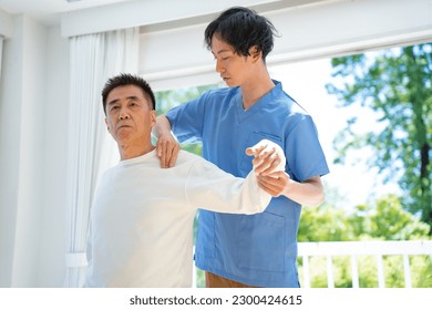 A man who massages and a Japanese senior man who receives treatment - Powered by Shutterstock