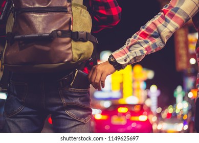 Man who stole the Backpacker tourist  cash. Hand that stealing money from the back pocket of the trousers. Warning - thieves and pickpocket in the night city.