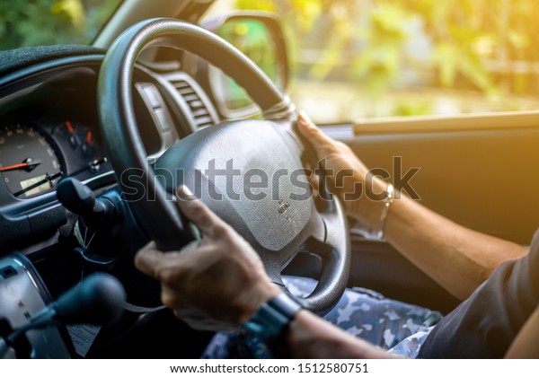 Man who wearing watch is driving vehicle while\
working or going to\
somewhere.