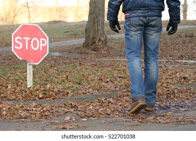 The man, whose face is not seen, goes on autumn Park with his back to us, prohibition sign 