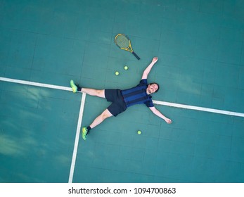 Man Win Tennis Game And Lay On Court Top View