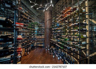 A man in a wine store with lots of bottles with wine