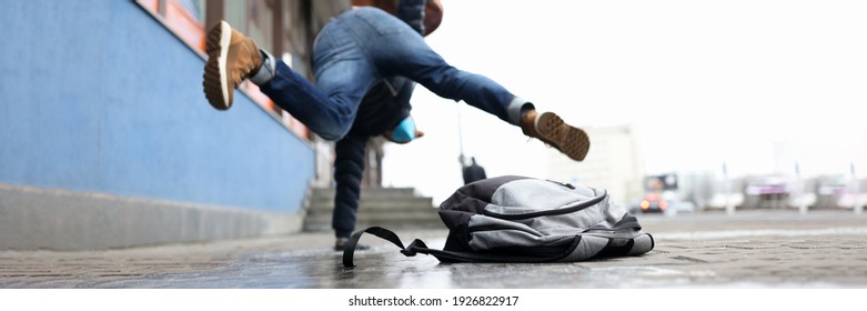 Man In Winter Dress Slip On Sidewalk With Ice Closeup Background. Heath Insurance Concept