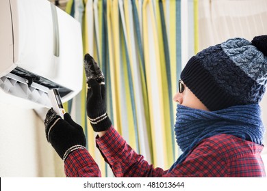 Man In A Winter Hat. It Is Cold In The House, Heating, Air-conditioned Room.