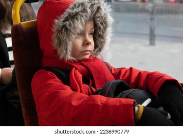 Man in winter red jacket rides in tram..