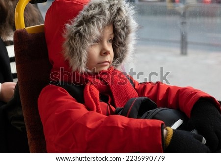 Man in winter red jacket rides in tram..