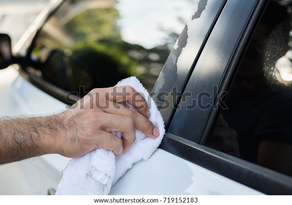 Man with wipe car glass\
cleaner