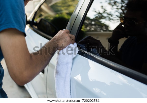 Man with wipe car glass\
cleaner