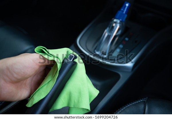 Man wipe clean surface,\
disinfectant spray in car for prevention coronavirus disease\
(covid-19) contamination of germs, health care concept (select\
focus)