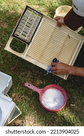 A Man Wipes The Front Grille Of A Window Type Air Conditioner With A Washrag And Soap Outside. Aircon Cleaning Service.