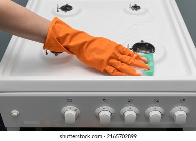a man wipes a gas burner with a sponge while cleaning. High quality photo