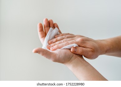 Man wipes his hands with a damp cloth from viruses and bacteria. human anti-coronavirus protection. antibacterial treatment of hands before eating.