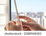 The man wipes the window frame with a degreaser and glues a sealing rubber tape on it for noise insulation, wind protection, weather protection.