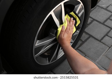 Man wiping car wheel with yellow rag, closeup - Powered by Shutterstock