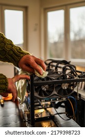 Man Wiping Cryptocurrency Mining Rig With Rag