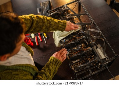 Man Wiping Dust From Cryptocurrency Mining Rig With Rag