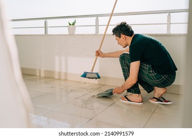 Man Wiping Floor With The Mop. Janitor Washing The Dirty Floors. Guy Mopping The Balcony On A Sunny Day. Person Doing Home Chores. Young Fellow Using Cleaning Equipment To Dust The Surface.