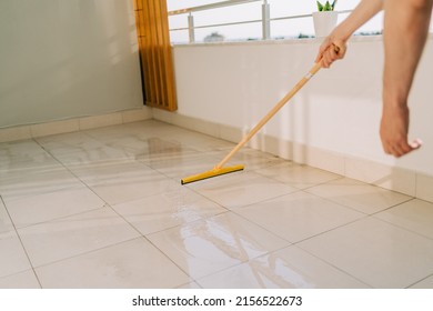 Man Wiping Floor With The Mop. Janitor Washing The Dirty Floors. Guy Mopping The Balcony On A Sunny Day. Person Doing Home Chores. Young Fellow Using Cleaning Equipment To Dust The Surface.