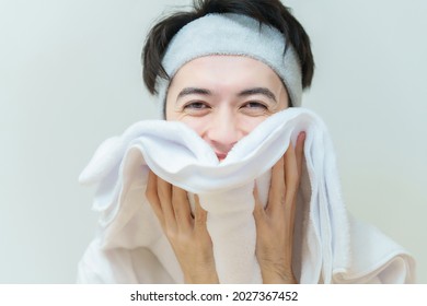 A Man Wiping His Face With A Towel