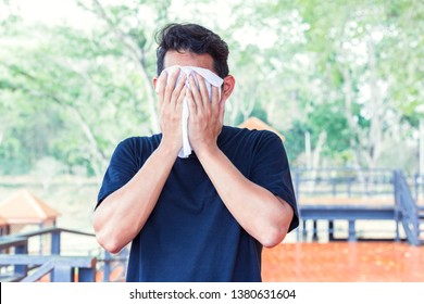 Man Wiping Off The Sweat On Face  Because Hot Weather  In The Parks