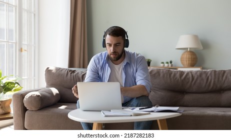 Man In Wireless Headphones Looks At Laptop Communicates To Client Provide Counsel Help Distantly Use Videoconference Application. Education, E-learning, Audio Course To Improve Language Skills