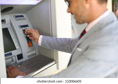 Man Withdrawing Money From ATM Machine