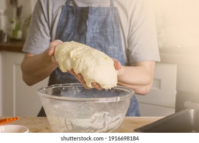 A Man Without A Face In An Apron Holds Raw Bread Dough In His Hands, A Home Baker. Authentic Home Cooking Hobby