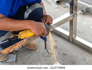 The Man Without Personal Protective Equipment Use Electric Grinding Stainless Steel In Workshop.