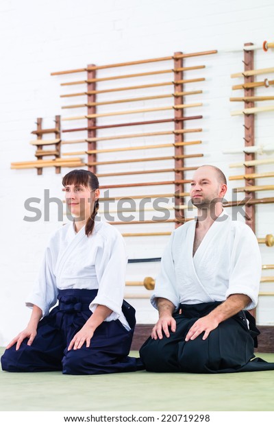 Man\
and woman at Aikido training in martial arts school\
