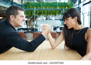 man and woman arm wrestling competition on the table