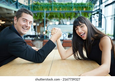 man and woman arm wrestling competition on the table