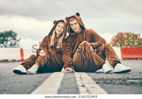 man
and woman in bear costumes are sitting on the road. young couple
fights hands. concept of care, love and
relationships