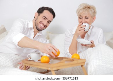 Man and woman in bed. Fun, frolic a mature couple. Showing love by mature person. Pleasant morning a couple of lovers. Breakfast in bed. Time for coffee. - Shutterstock ID 356771813
