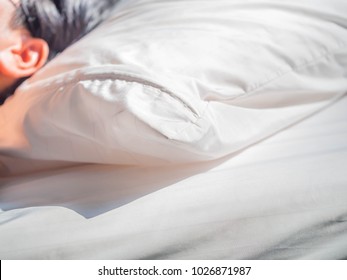 Man Or Woman In The Bedroom With White Dust Mites Pillow And Bedding Cover And Sunlight In The Morning.