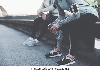 Man and woman before urban workout. Couple preparing for running and sitting on the bench on the street - Powered by Shutterstock