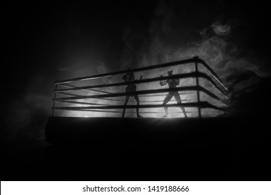 Man and woman boxing on the ring. Sport concept. Artwork decoration with toys on foggy toned dark background. - Powered by Shutterstock