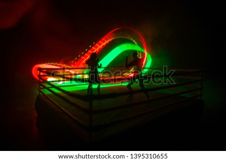 Man and woman boxing on the ring. Sport concept. Artwork decoration with toys on foggy toned dark background.