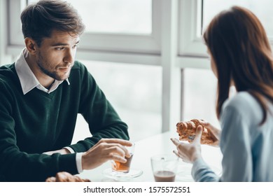 Man and woman breakfast in a cafe near the window of a family table