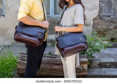 Man And Woman With Brown Leather Messenger Bag In The Hand. Unisex Bag