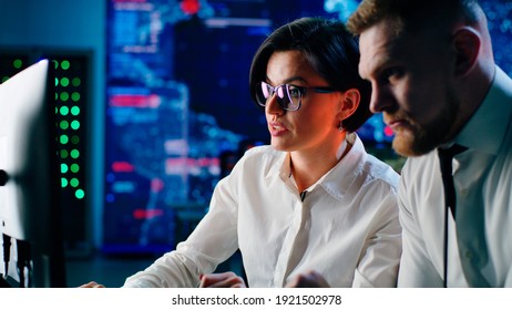 Man And Woman Browsing And Discussing Data On Computer While Working Together In High Tech Digital Security Center