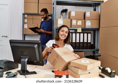 Man and woman business partners scanning package using barcode reader at storehouse