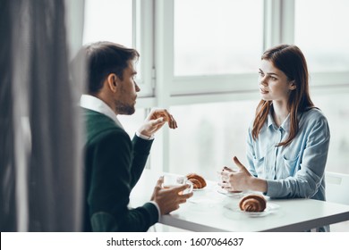 Man and woman in a cafe at the table eating and communicating