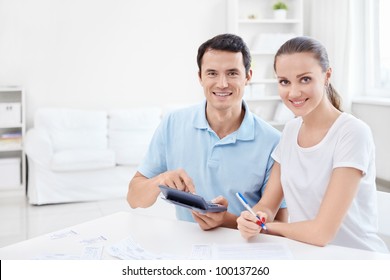 Man And Woman With A Calculator At Home