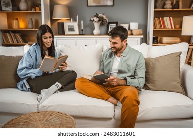 man and woman caucasian adult couple read books at home on sofa bed	 - Powered by Shutterstock