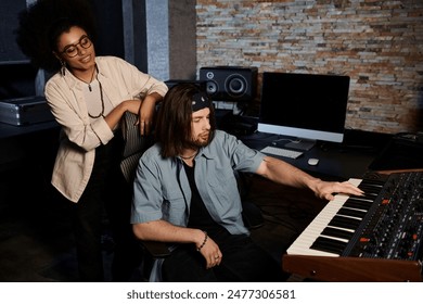 A man and a woman collaborate on music in a recording studio as they rehearse for their band. - Powered by Shutterstock