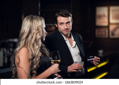 a man and a woman come to a nightclub and drink cocktails.