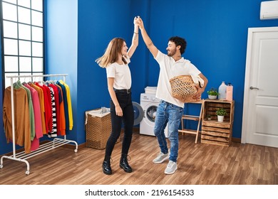 Man And Woman Couple Dancing And Holding Basket With Clothes At Laundry Room