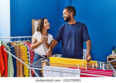 Man And Woman Couple Drinking Coffee Hanging Clothes On Clothesline At Laundry